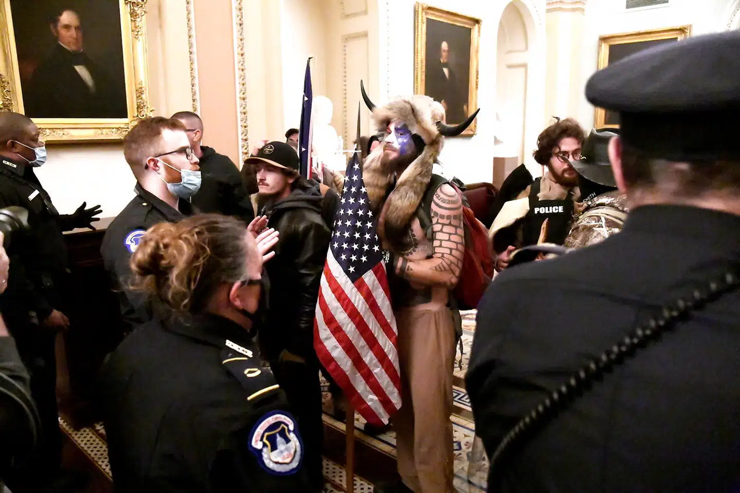 En ledende figur i den kontroversielle konspirationsbevægelse QAnon spillede en synlig rolle. Under optøjerne blev Jake Angeli set vandre rundt i Kongressen med en megafon, mens han fik taget billeder med både Trump-støtter og QAnon-tilhængere.