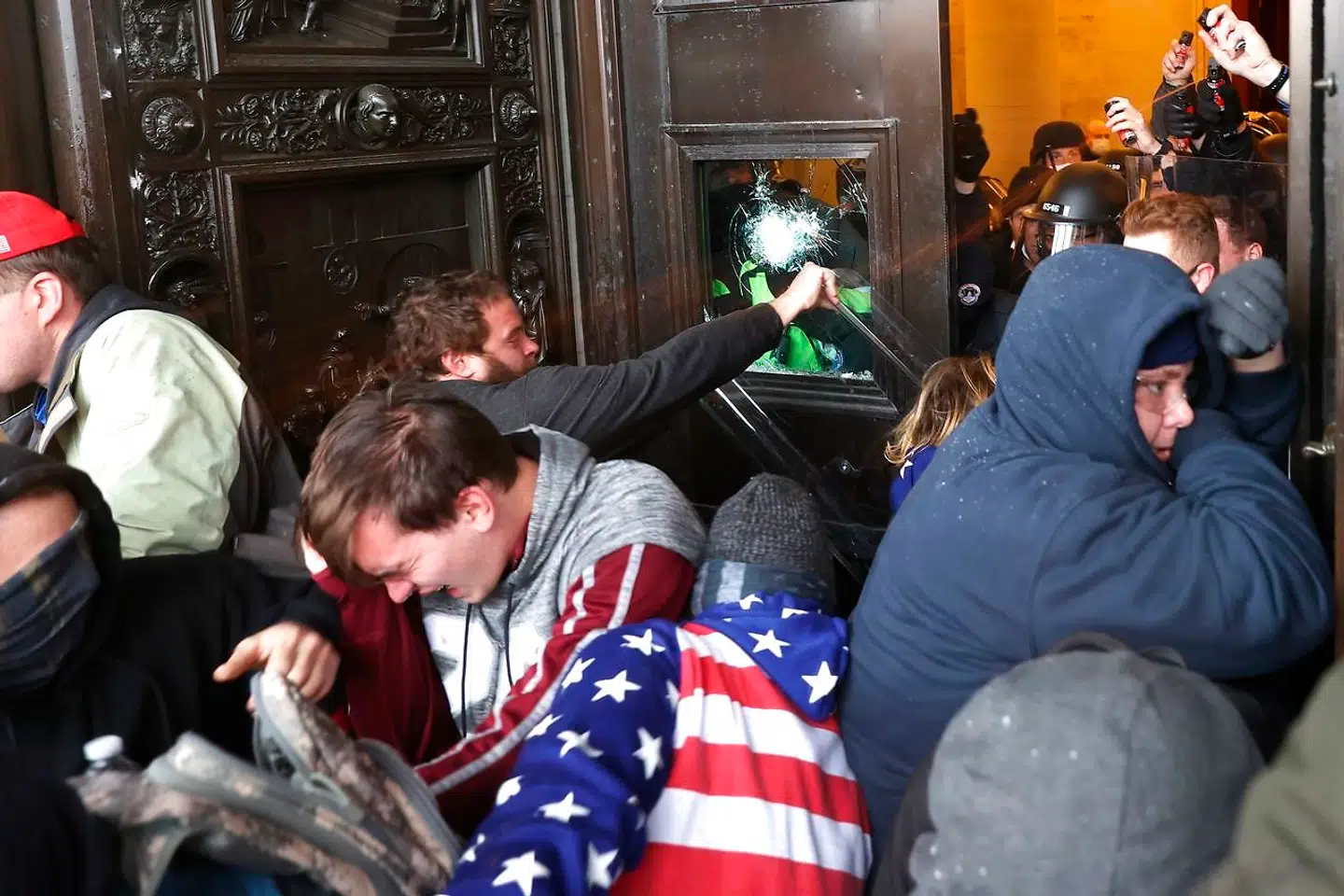 Trump-tilhængere forsøger at trænge ind gennem Kongressens dør.