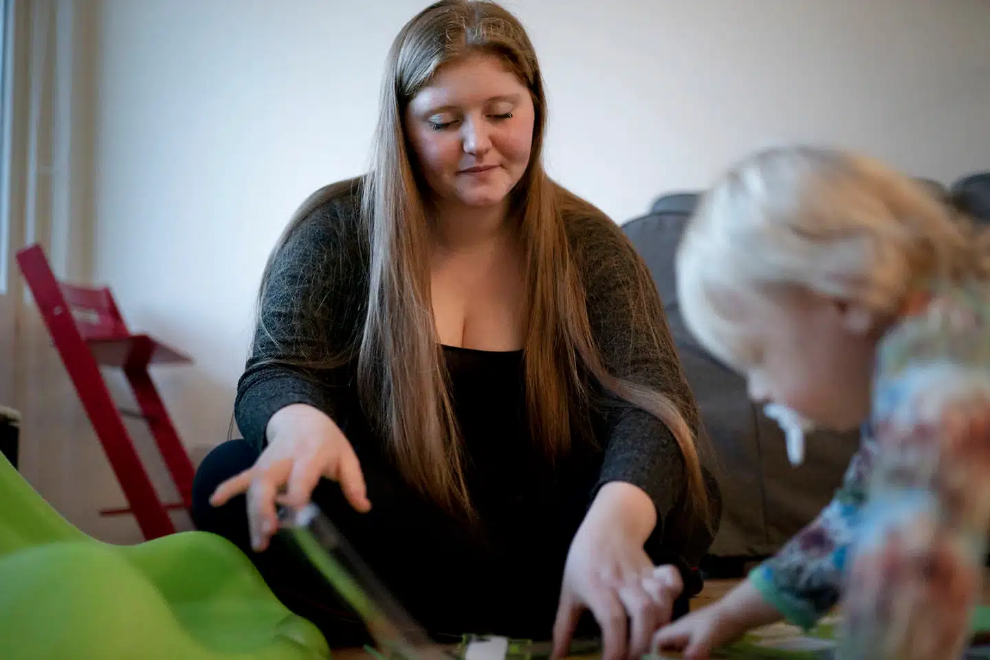 21-årige Sarah Højhus og hendes søn, Liam, sidder på gulvet og leger. De er vant til at blive observeret, når de er sammen.