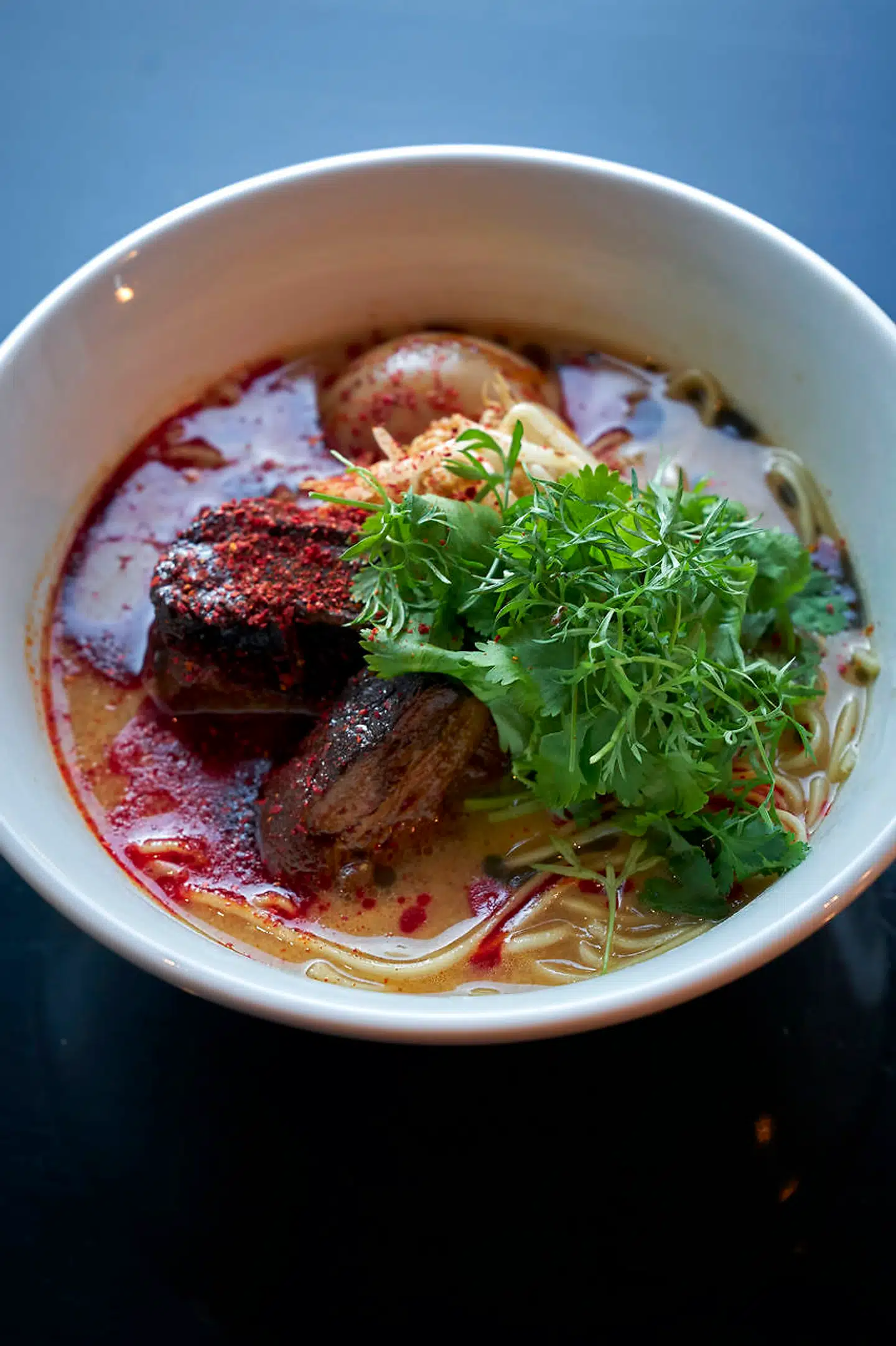 Ramen kommer med smilende æg, bønnespirer og nudler.