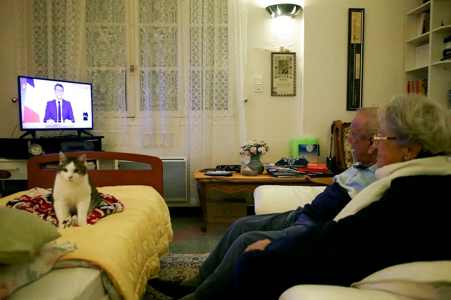 Et ældre ægtepar i Cognocoli-Monticchi på middelhavsøen Korsika følger præsidentens tale til nationen på TV.