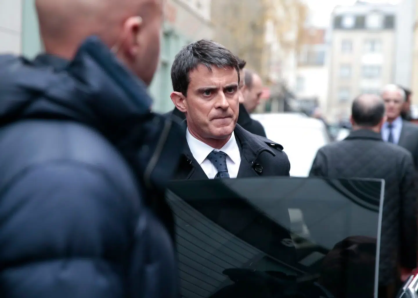 En sammenbidt og tydeligt påvirket Manuel Valls forlader politihovedkvarteret i Paris' 11. arrondissement efter en briefing om massakren på Charlie Hebdo 7. januar 2015. Den daværende premierminister besøgte selv satiremagasinet, mens ligene af de dræbte redaktionsmedlemmer – heriblandt hans personlige ven, tegneren »Cabu« – endnu lå lokalerne.