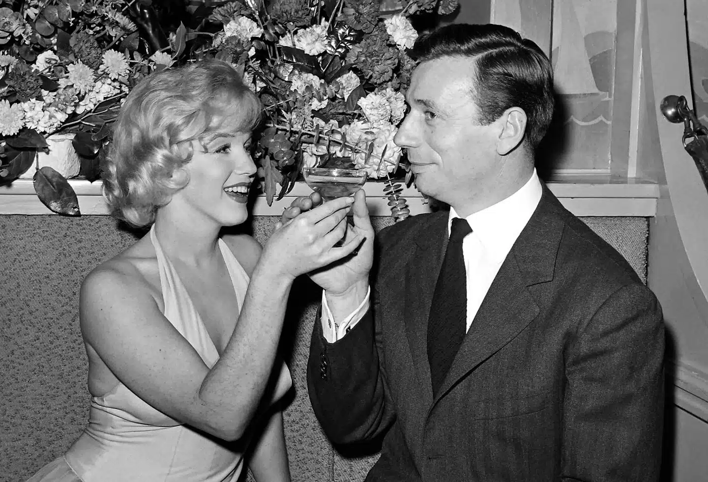 Før i tiden drak vi champagne til højtiderne. Nu er fredag også en højtid, siger vinhandlerne. Her får Marilyn Monroe og Yves Montand sig et glas bobler efter premieren på »Let's Make Love« i 1960.