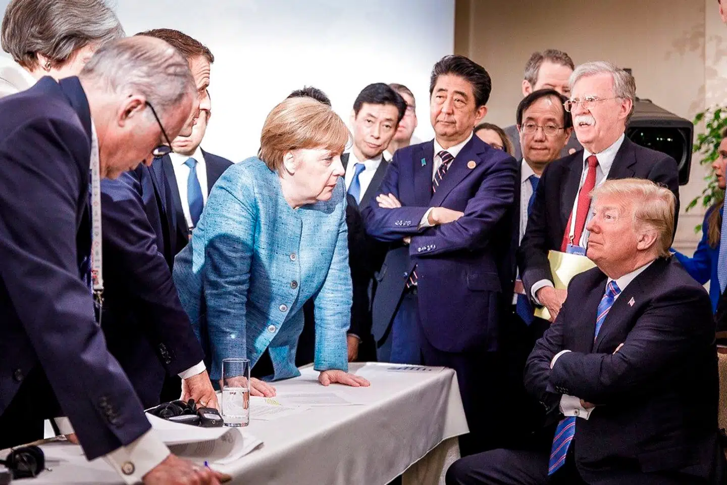 Dette foto er blevet ikonisk og blev tweetet af den tyske regerings talsmand, Steffen Seibert. Det er taget af den tyske regerings fotograf i forbindelse med G7-mødet i Quebec i Canada i juni 2018, som endte kaotisk, fordi Donald Trump forlod mødet, uden at slutkommunikeet var færdiggjort. Da han opdagede det undervejs til et møde med Nordkoreas leder, Kim Jong-un, trak han tæppet væk ved at nægte at acceptere konklusionerne.
