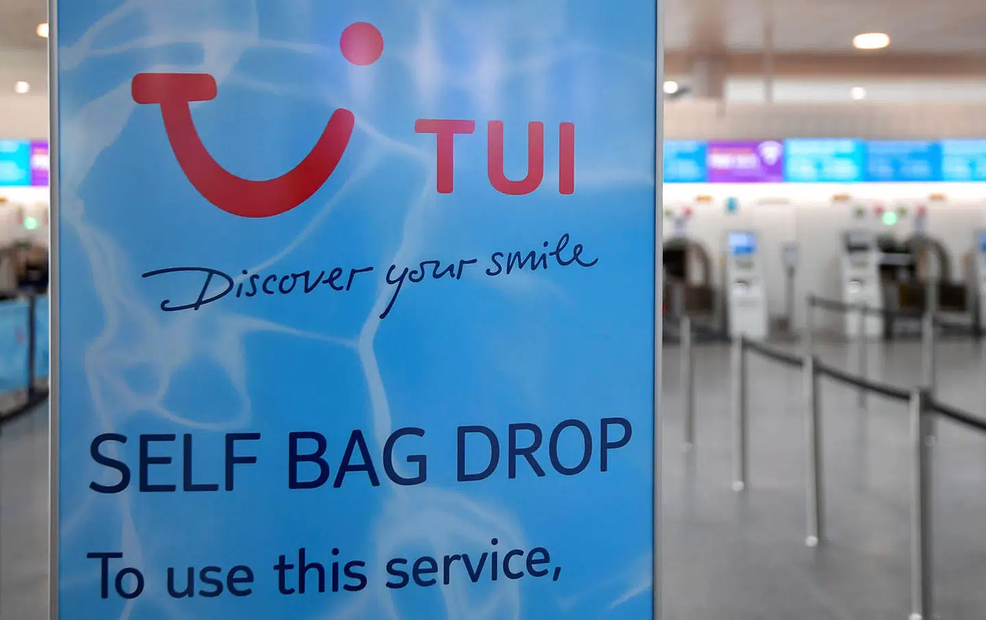 Den tyske rejsegigant TUI udskyder nu betalingen for de turister, som nåede at komme til Grækenland i år, til marts næste år. Her ses et TUI-skilt i Gatwick Airport nær London i juli 2020, mens det stadig var muligt at rejse på badeferie i Grækenland.