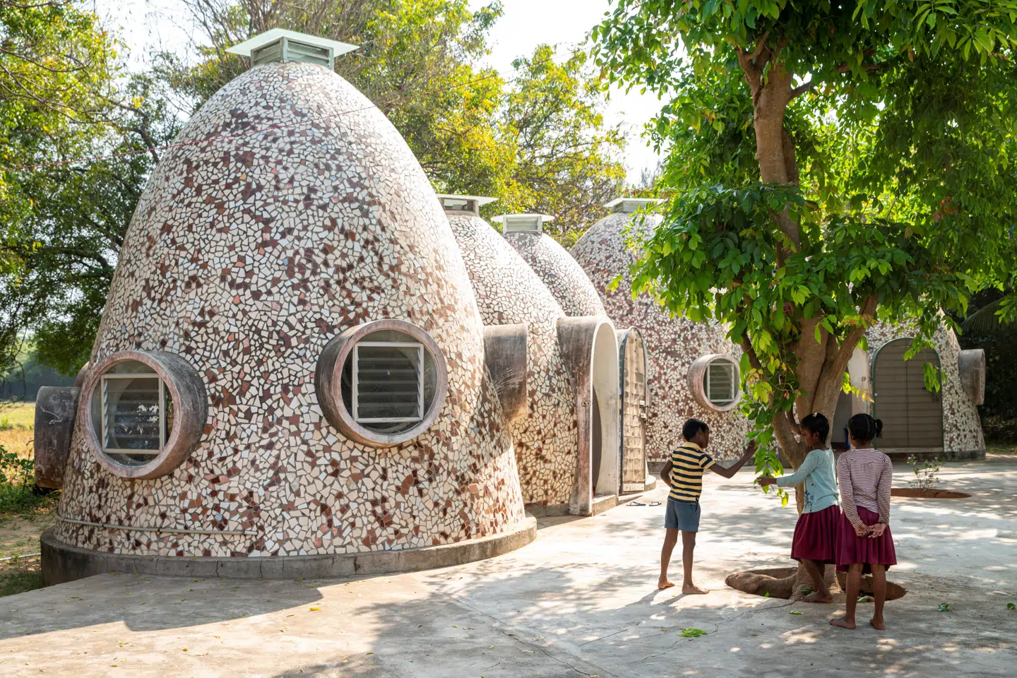 De »hjemmebrændte« hjemløseboliger, volontariat homes, som de kaldes, ligner noget fra en fjern, fortidig civilisation. Eller måske pupper til rumvæsener. Som alle Anupama Kundoos bedste projekter er de nærmest vokset direkte ud af jorden, de står på.