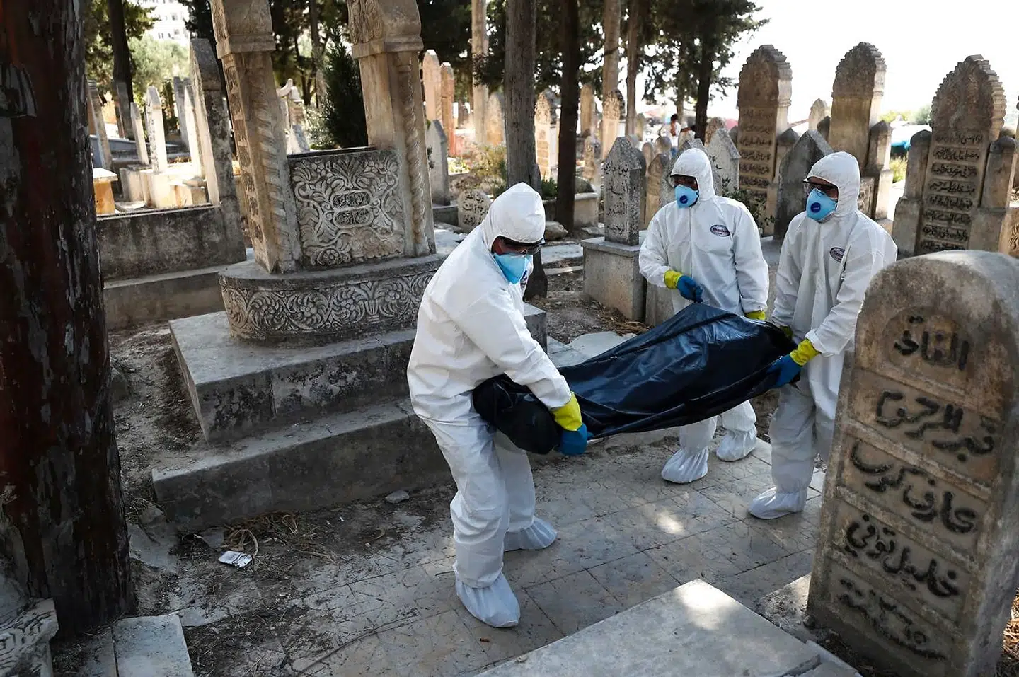 Officielt er der 4.774 smittetilfælde og 228 dødsfald med coronavirus i Syrien, hvilket placerer Syrien i toppen af verdens bedste lande. Men virkeligheden er en anden, skriver det uafhængige magasin Newlines Magazine. På billedet ses sundhedsarbejdere, der begraver en 62-årig mand, som døde af covid-19, i Idlib i det nordvestlige Syrien.