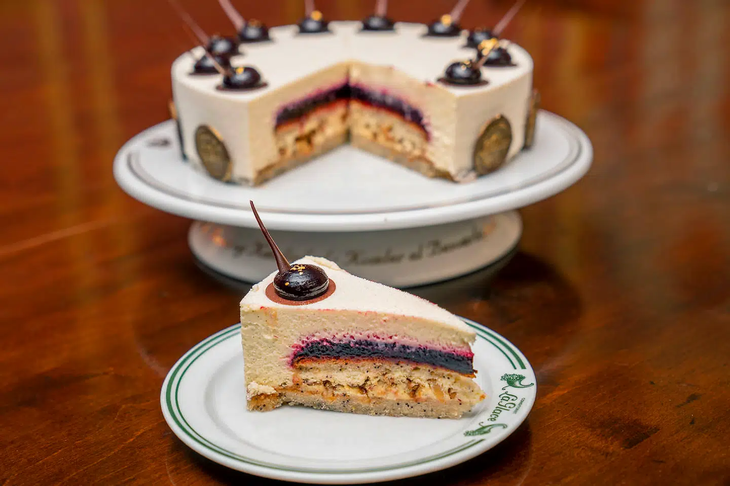 Der blæser nye vinde i Københavns ældste konditori, som fyldte 150 år i denne uge. Her den veganske jubilæumskage, som består af en lys bund med citron, blå birkes og vanilje, solbærgelé, brændte mandler og en citronmousse med hvid, vegansk chokolade.