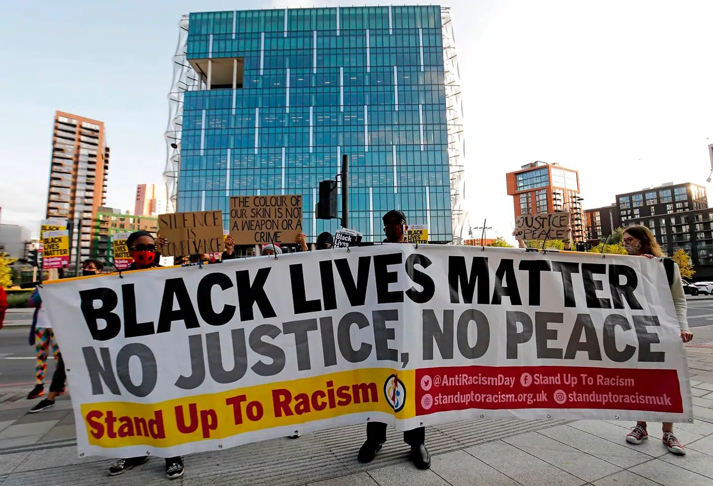 Protesters from Black Lives Matter hold up placards as they gather outside the US Embassy in London on September 11, 2020, the day of a trial hearing of the four police officers charged with the murder of George Floyd in the US. (Photo by Tolga AKMEN / AFP)