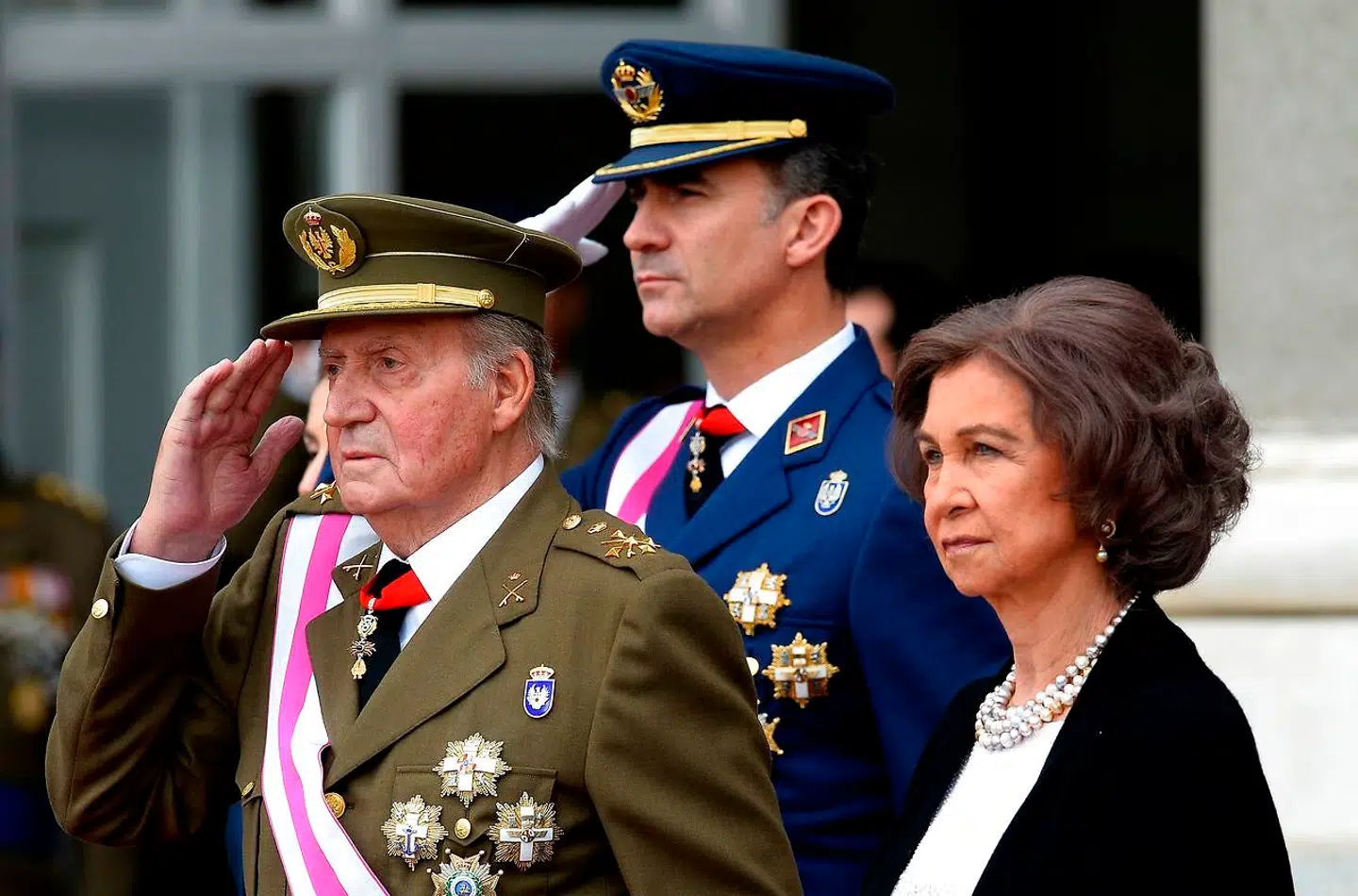 Juan Carlos og dronning Sofia, der her ses sammen under en militærparade i Madrid, har angiveligt ikke delt bord og seng i årtier. Historien om den nu landflygtige tidligere monarks deroute er et »firkantsdrama« med Corinna Larsen og nuværende kong Felipe VI (bagest) som hovedpersonerne.