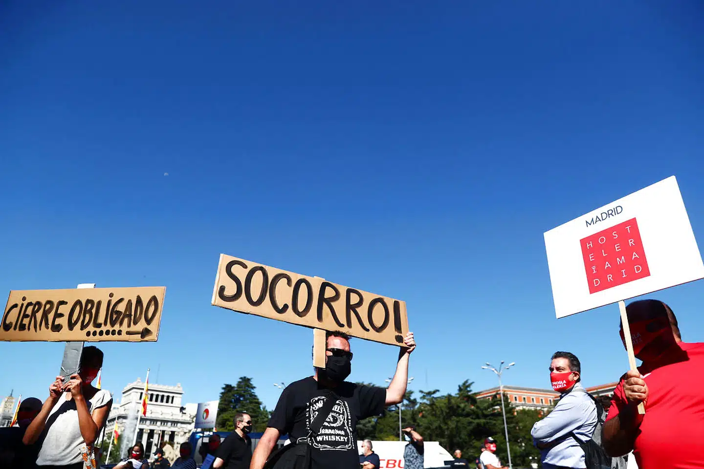 »Hjælp« står der på skiltene, som repræsentanter for hotel- og restaurationsbranchen holder op under en demonstration i Madrid. Afvejningen af hensynet til den kritiske økonomiske situation og behovet for at bremse smitten, er ekstremt vanskelig for de spanske myndigheder.