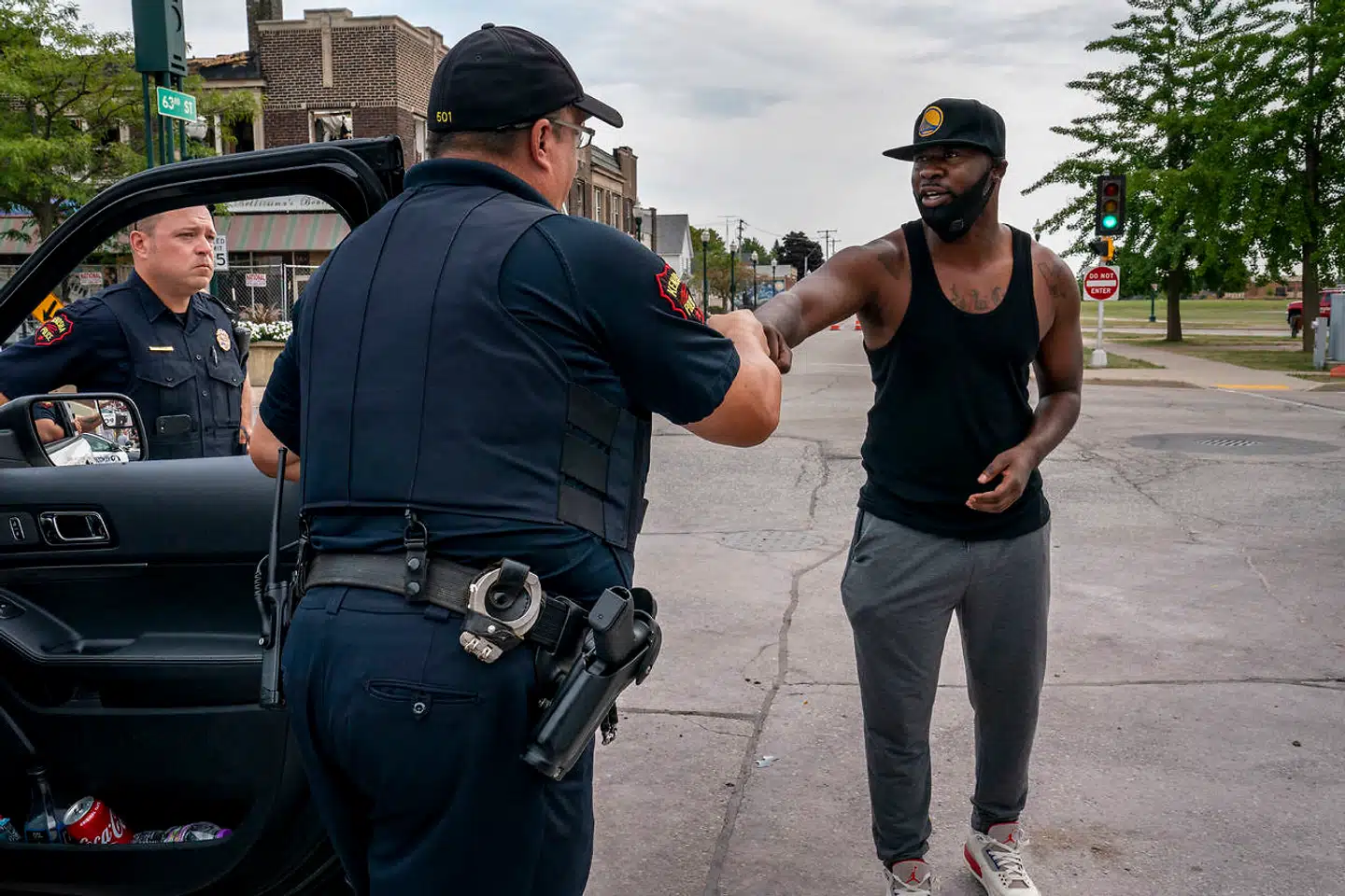 Lj-Ron Franklin hilser på et par lokale politibetjente på gaden i Kenosha. Han synes ikke, at Trump burde komme til byen »med alt sit had«.