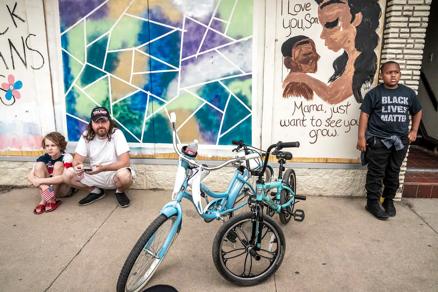 To forskellige verdenssyn: en Trump-tilhænger med sit barn kontra en dreng med en Black Lives Matter-T-shirt.