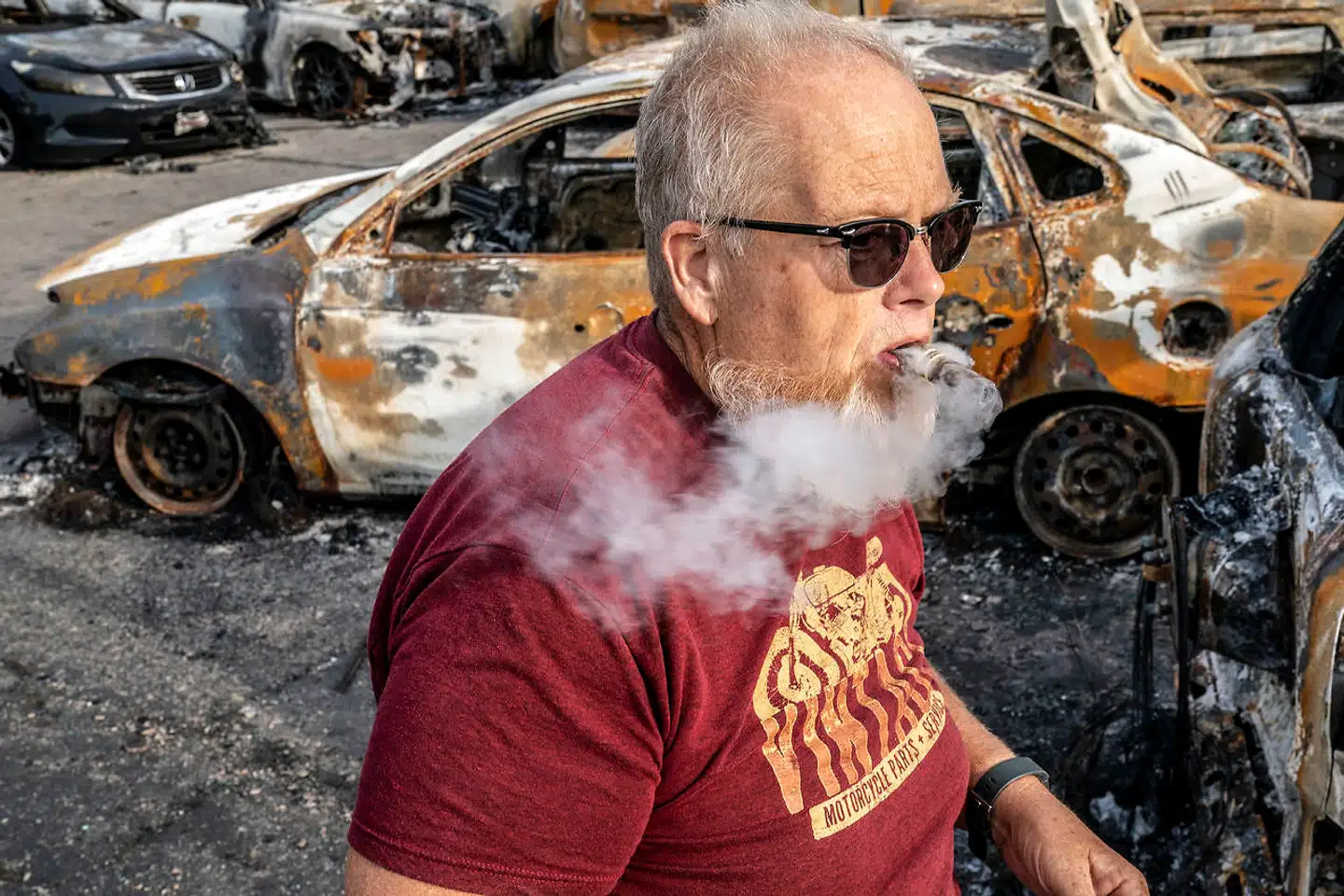Bryan Svendsen foran nogle af de mange biler, der er blevet sat i brand under uroligheder i Kenosha i staten Wisconsin.