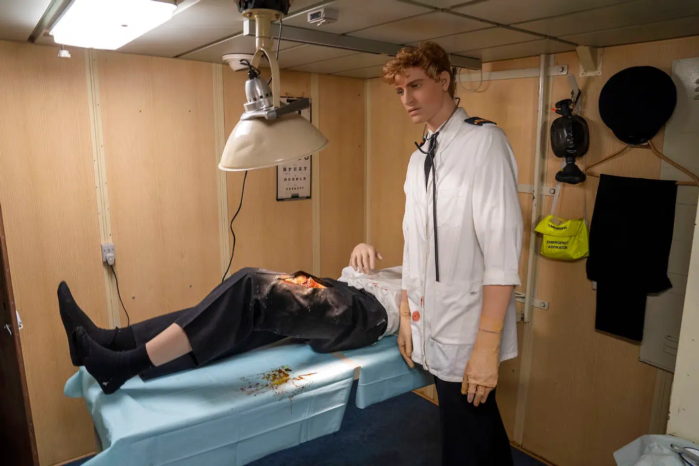 En læge tilser sin patient på Fregatten Peder Skram, der i dag fungerer som museum.