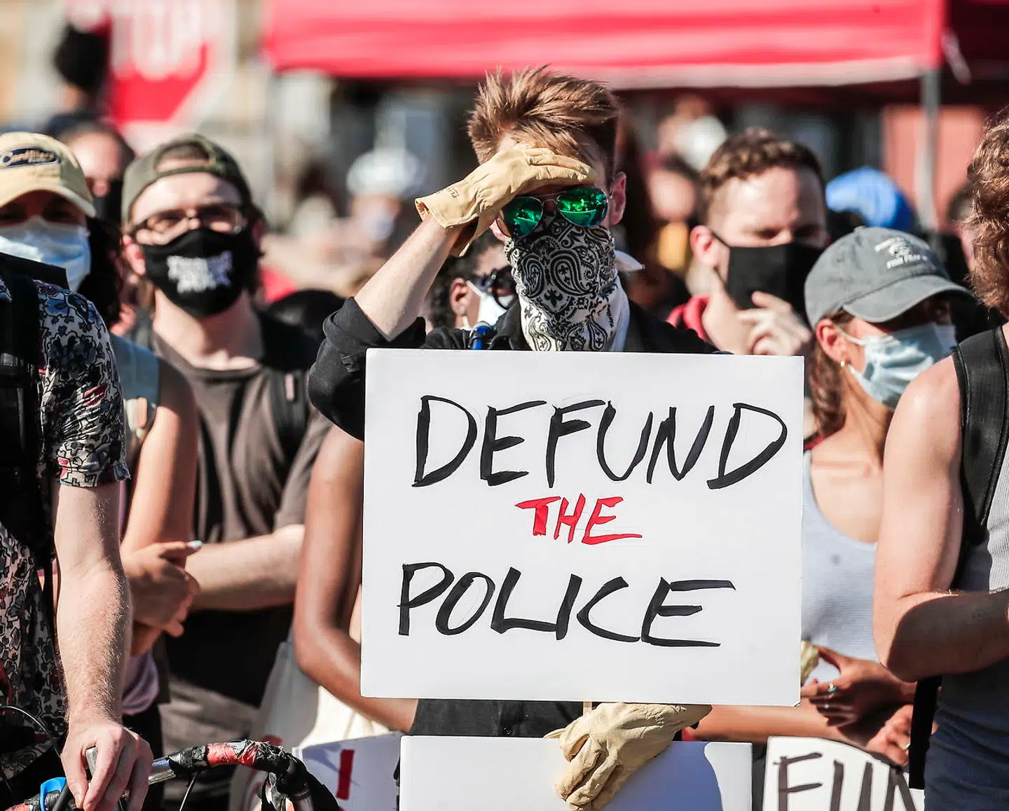 Protesterende holder et skilt op med teksten »defund the police« – fjern finansieringen af politiet – som er blevet et krav fra demonstranter i kølvandet på politidrabet på George Floyd i maj.