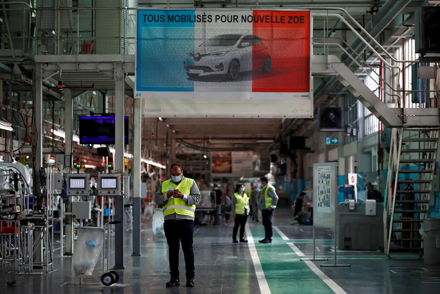 Det har længe været almindeligt at bruge mundbind i en række virksomheder som her i Renaults bilfabrik i Flins nær Paris. Men nu gør den franske regering det obligatorisk på alle arbejdspladser.