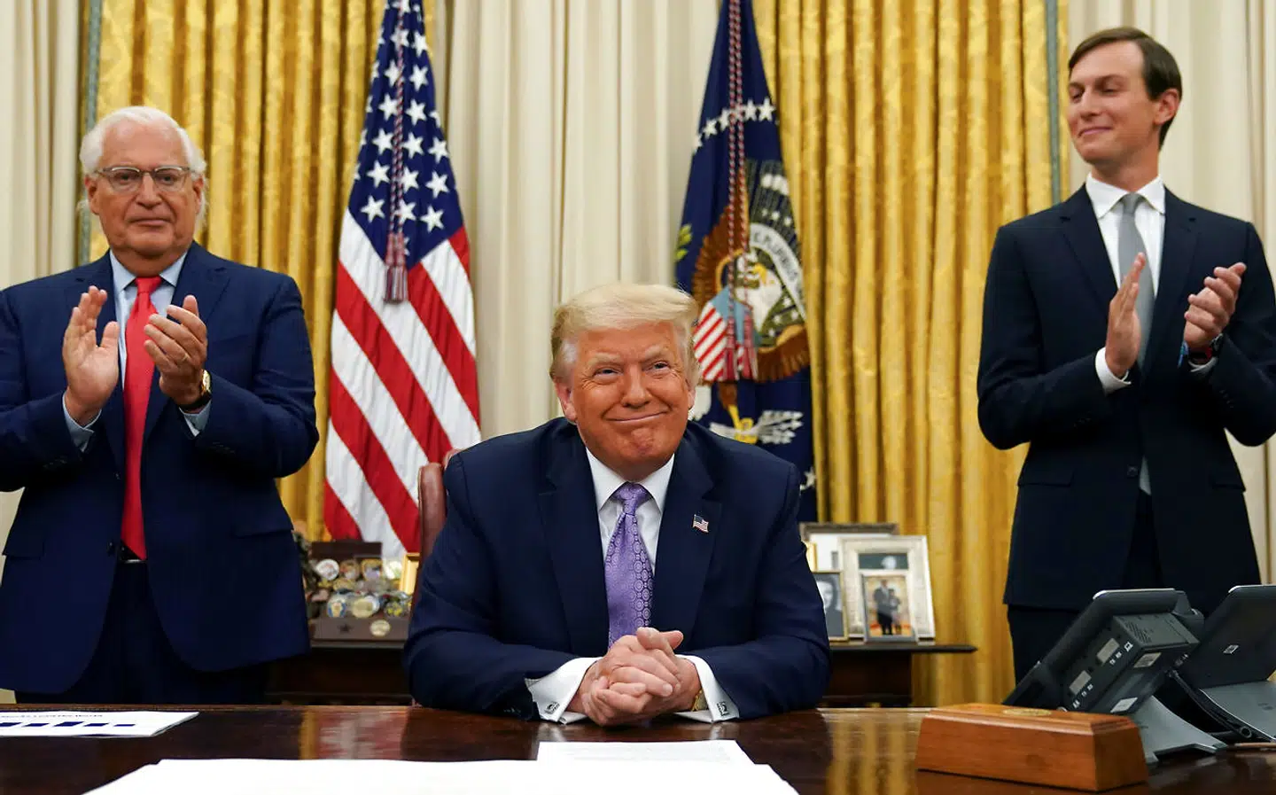 USAs ambassadør i Israel, David Melech Friedman (tv.) og den amerikanske præsidents rådgiver og svigersøn Jared Kushner (th.) klapper af fredsaftalen, som Donald Trump er overordentlig tilfreds med.