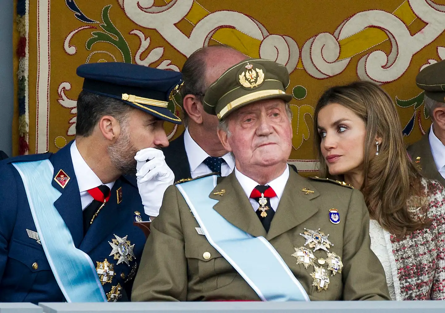 Felipe og Letizia hvisker bag kong Juan Carlos’ ryg under en militærparade i 2012, mens de endnu var kronprinsepar. Ifølge spanske medier har den nuværende dronning været med til at lægge pres på sin mand for at tage det definitive opgør med ekskongen og tvinge ham i eksil.