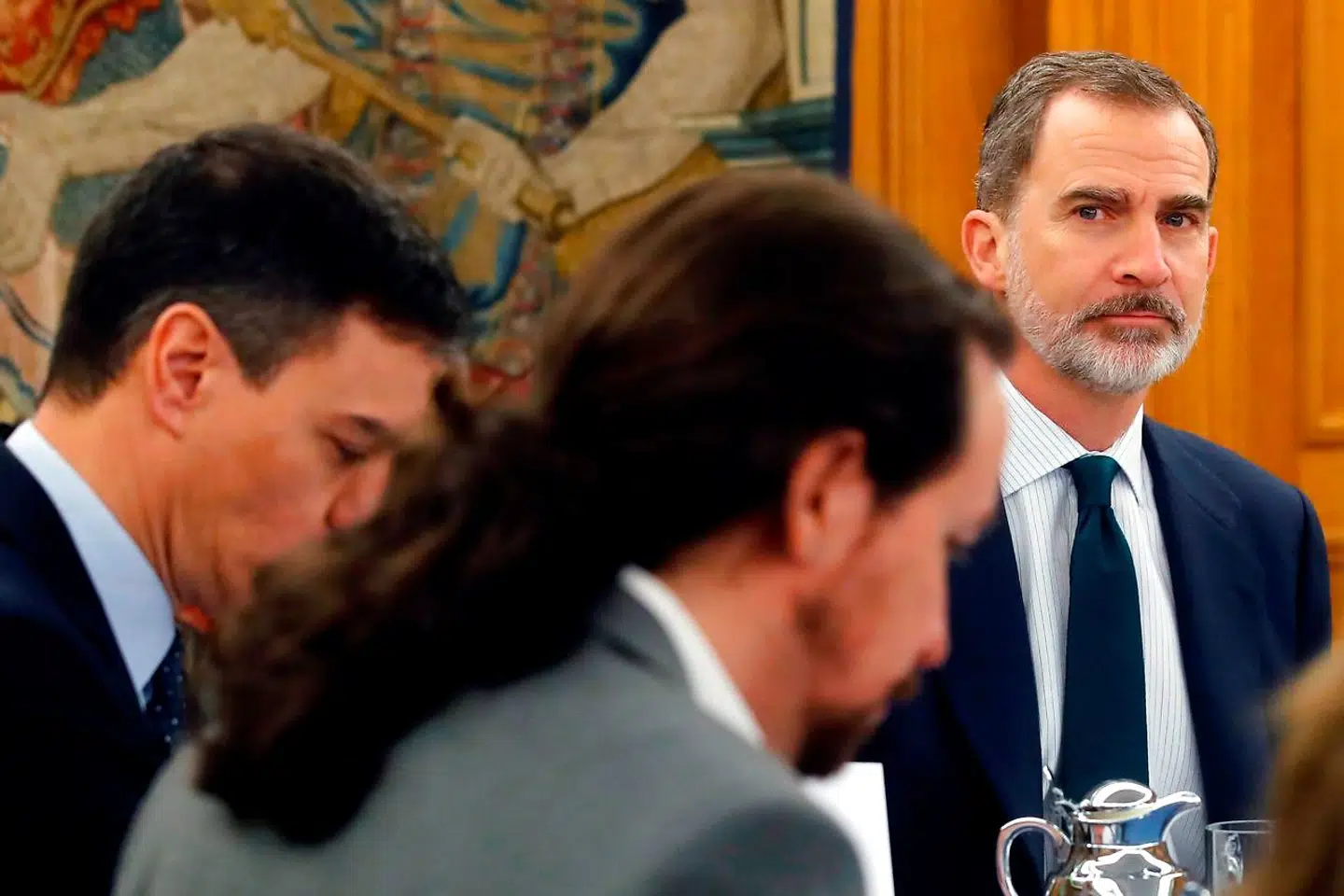 Ifølge Podemos-lederen Pablo Iglesias Turrión (med hestehalen), der her ses under et regeringsmøde med premierminister Pedro Sánchez ved sin side og Felipe VI for bordenden, befinder monarkiet efter ekskongens eksil sig i en »uholdbar situation«.