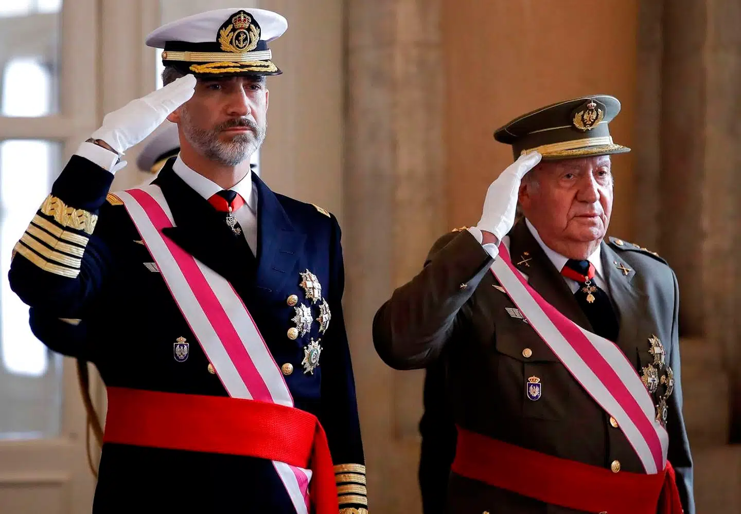Felipe VI og Juan Carlos I gør honnør under en militærparade i januar 2018. Senere samme år indledte en schweizisk anklager den undersøgelse af ekskongens økonomiske aktiviteter, der har fået Spaniens nuværende monark til at slå hånden af sin far.