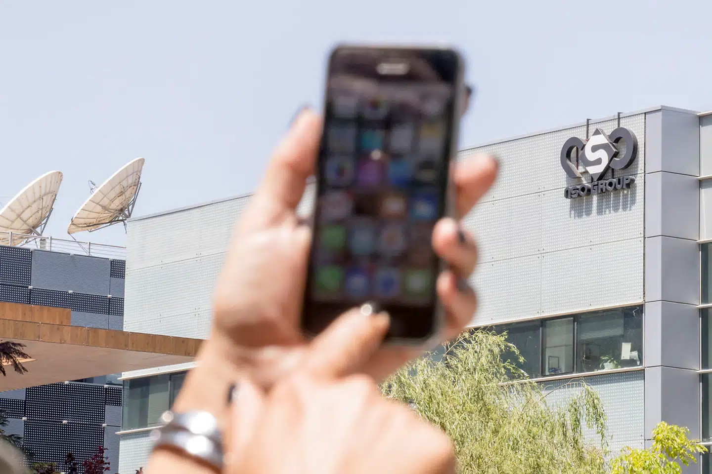 En kvinde bruger sin mobiltelefon uden for NSO Groups hovedkvarter nær Tel Aviv. Det israelske firmas Pegasus-program blev sidste år brugt til at angribe en række WhatsApp-brugere under en flere uger langt sikkerhedsbrist i den populære applikation.