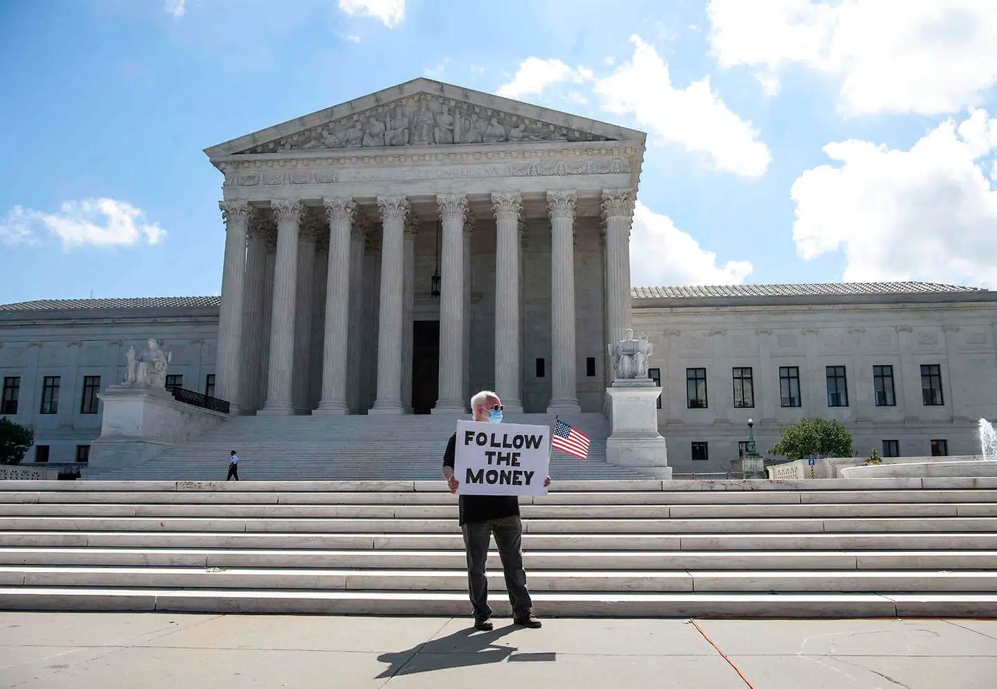 En mand demonstrerer med en opfordring om at følge pengene, forud for den amerikanske højesterets kendelse om Donald Trumps skattepapirer.