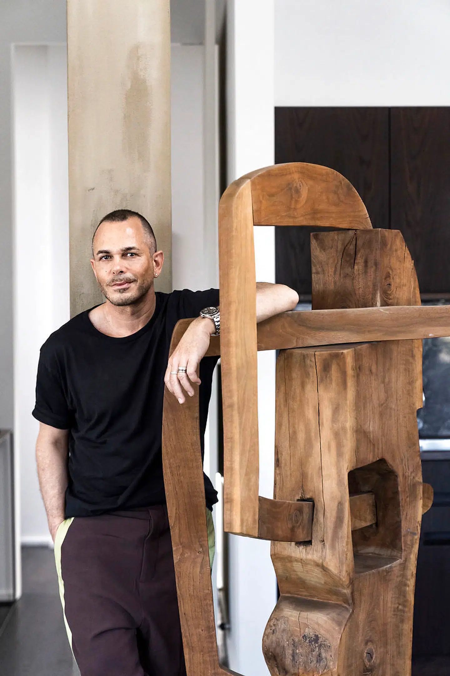 Uffe Buchard i sin lejlighed, hvor han har masser af kunst, både malerier, skulpturer og keramik. Kunstneren bag denne træskulptur er ukendt. Den er et fund fra en af Bruun Rasmussens auktioner.