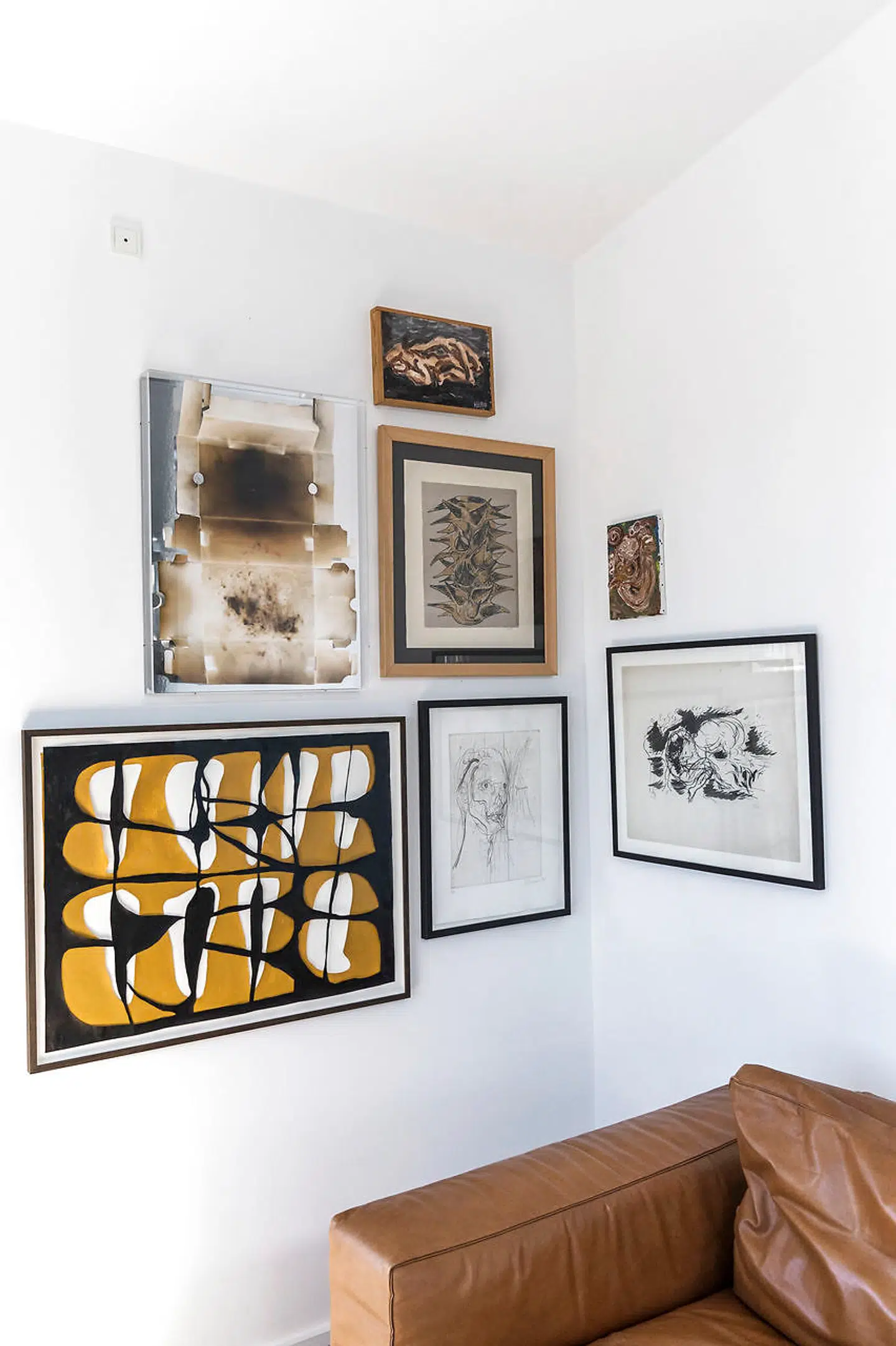 Uffe Buchardts billedvæg. Værket i sort og okkergult er en nyanskaffelse af Mathias Malling Mortensen og over det hænger et nyt værk af Morten Plesner. Fra oven i næste række et lille Jeff Ibbo. Under det en skitse af Axel Salto og under den et Christian Lemmerz. På den anden væg en stor tuchtegning af Axel Salto og oven på den en miniature CoBrA købt for mange år siden.