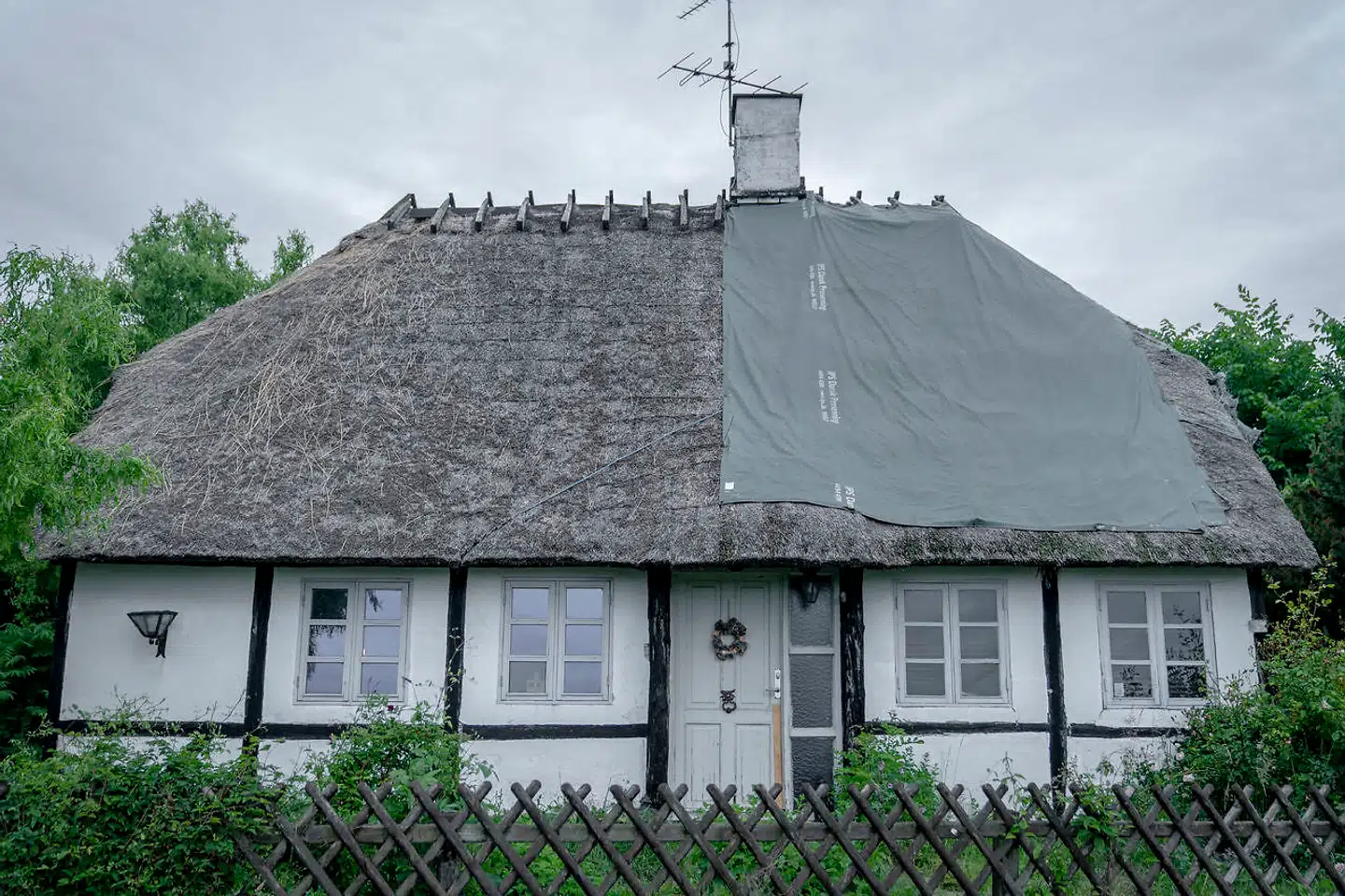 I Holeby er en pressening lagt hen over halvdelen af et stråtækt tag. Lejeren i dette hus kan kun trække på skulderen og sige, at han er blev lovet bedring af udlejerne, men endnu ikke har set det ske. Det står det halvt afpillede tag og vidner om. Nu flytter han og hans to kammerater, der bor i huset. Ejendommen er blevet solgt videre i netværket.