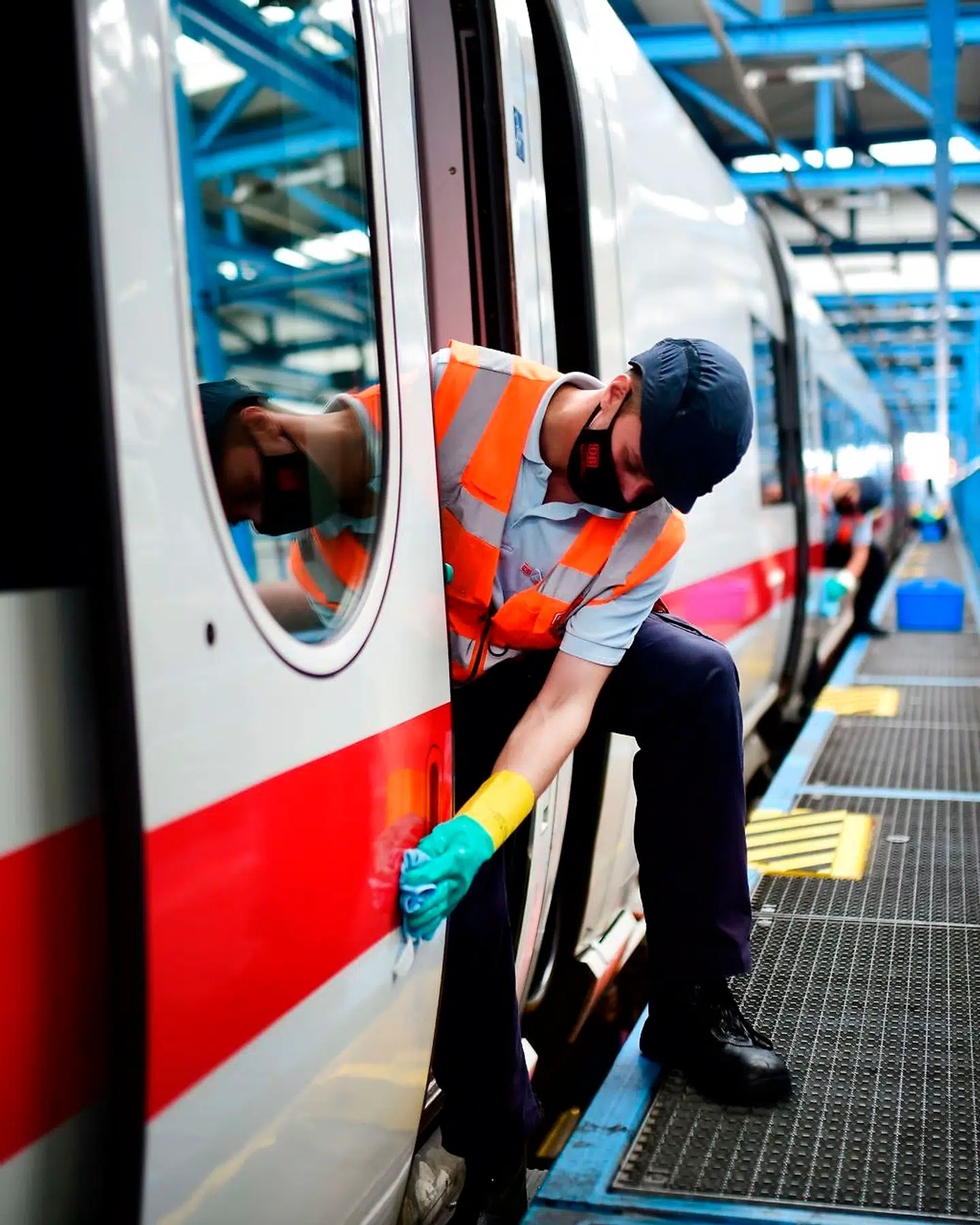 En ansat afspritter indgangsdøren til et tysk tog. Høje standarder for hygiejne bliver afgørende for at genvinde borgernes tillid til offentlige transportmidler.