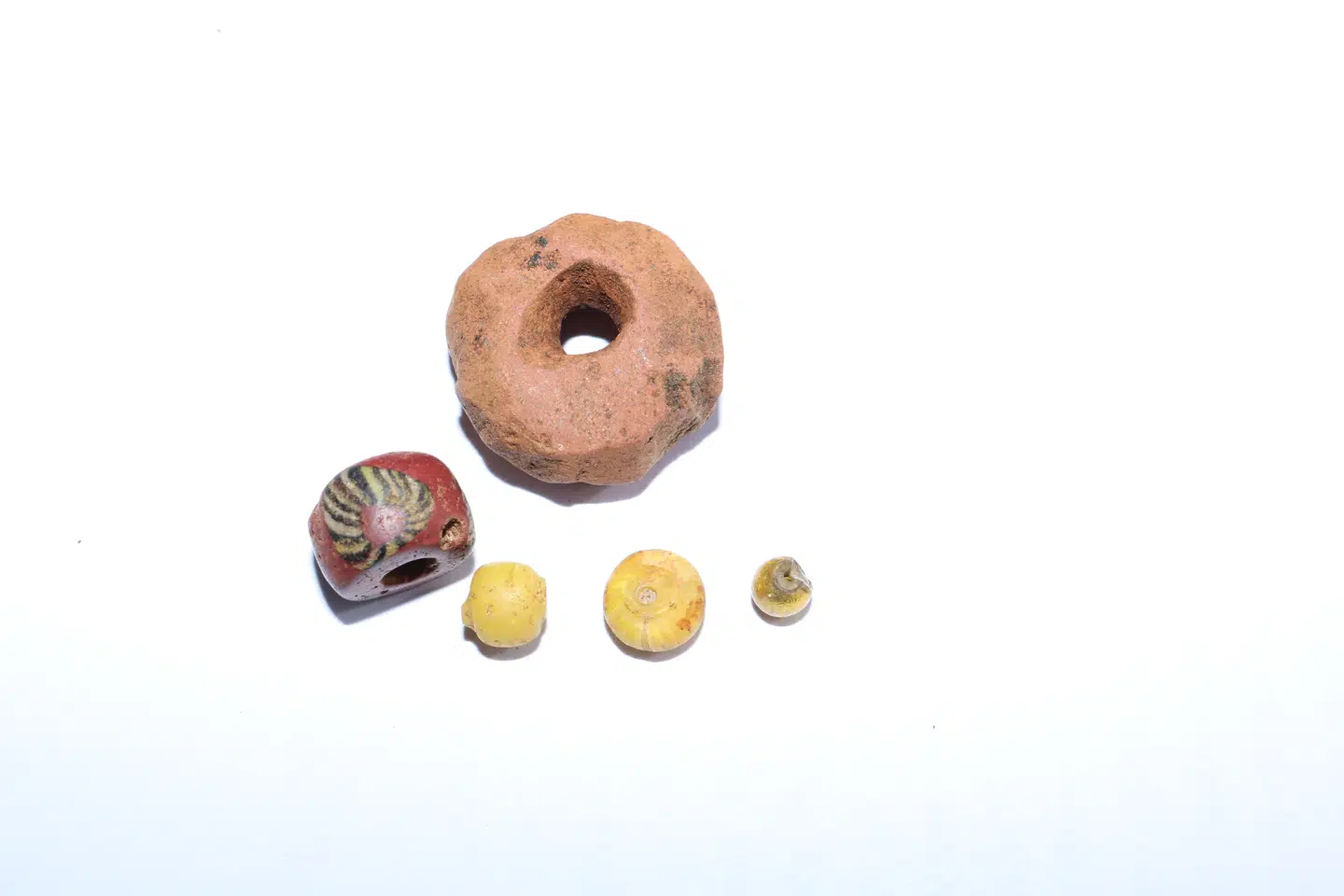 Perler af forskellige materialer fundet i det yngste langhus fra omkring 847 efter Kristus.