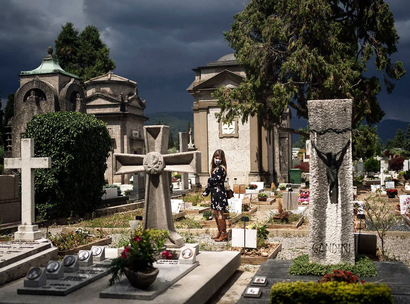 Cristina Longhini står på Bergamos centrale kirkegård. Hendes far døde i slutningen af marts, men han fik ikke nogen bisættelse. Hun måtte blive udenfor porten til kirkegården og fik ikke lov til at komme ind, da farens urne skulle anbringes.