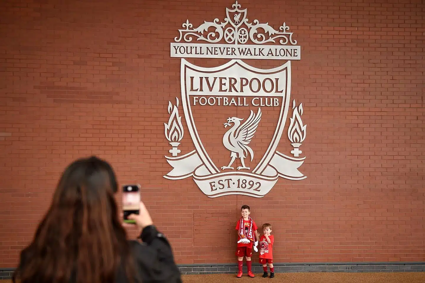 Liverpool har inden for et år vundet den engelske, den europæiske og den globale turnering. Her er lokale fans fredag på fototur til Liverpools hjemmebane, Anfield.