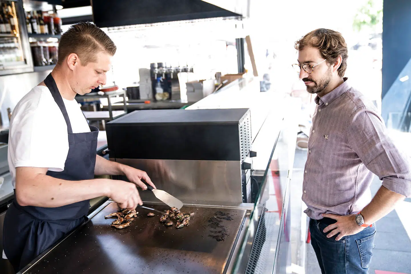 Planchaen er omdrejningspunkt for hele konceptet i den nye spisebar. Kokken lynsteger din mad, og den serveres ved disken.