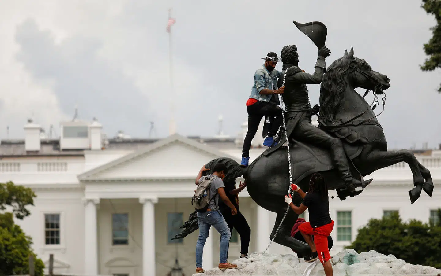 Demonstranter binder en kæde til en statue af tidligere præsident Andrew Jackson foran Det Hvide Hus i Washington D.C. med det formål at forsøge at vælte den. Nu truer Trump med ti års fængsel til personer, der vandaliserer eller vælter offentlige monumenter i landet.