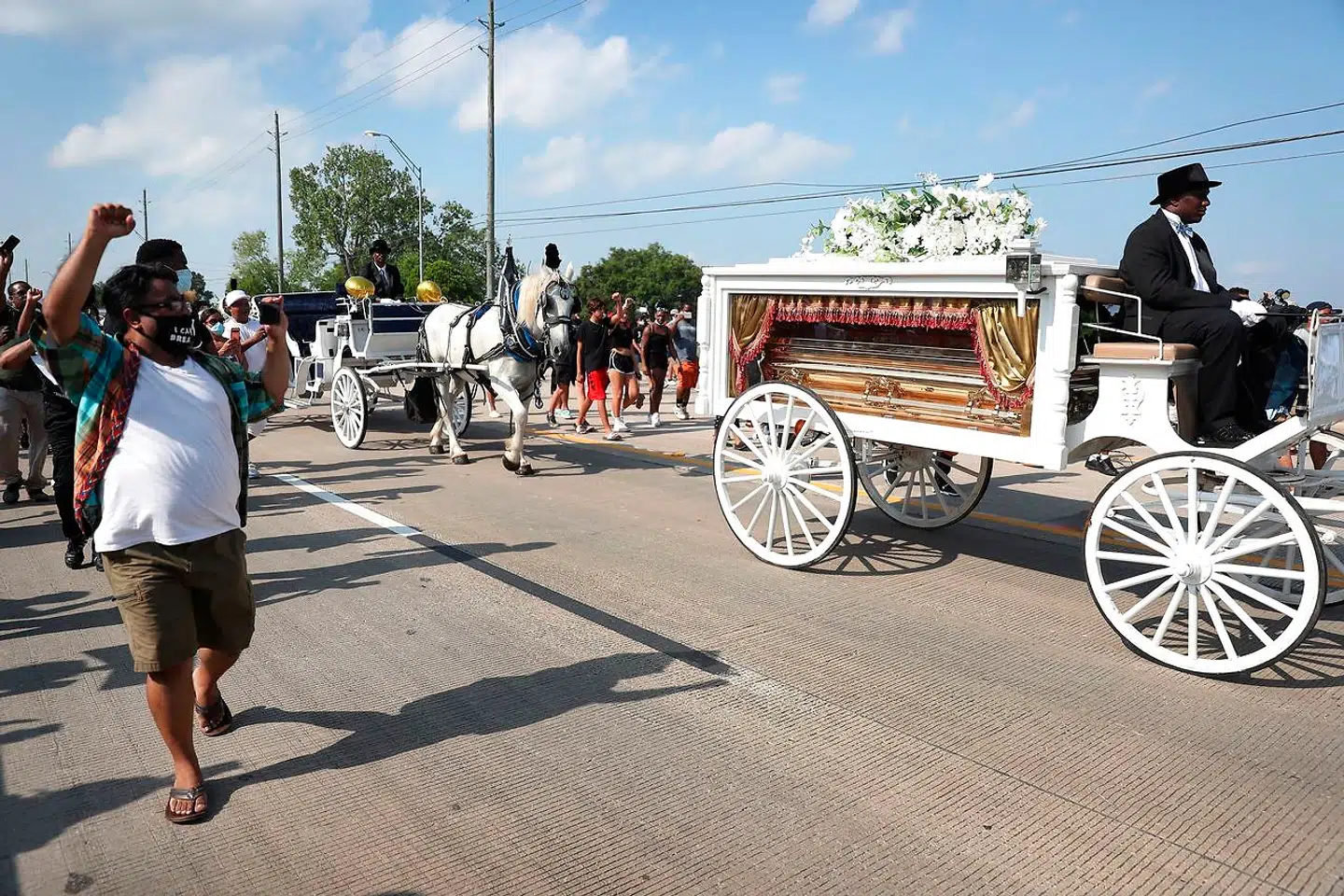 Folk fulgte en hestetrukken karet med George Floyds guldkiste, da han tirsdag blev begravet.