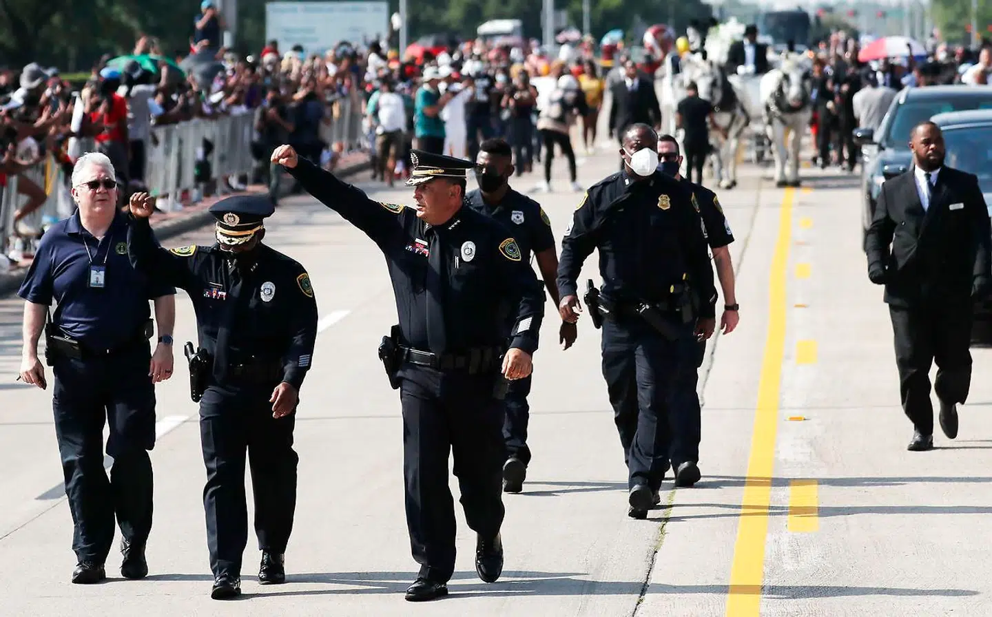 Houstons politichef, Art Acevedo, rejser sammen med en anden betjent en knyttet næve for at vise, at de støtter de protesterendes kamp om at støtte politivold mod sorte.