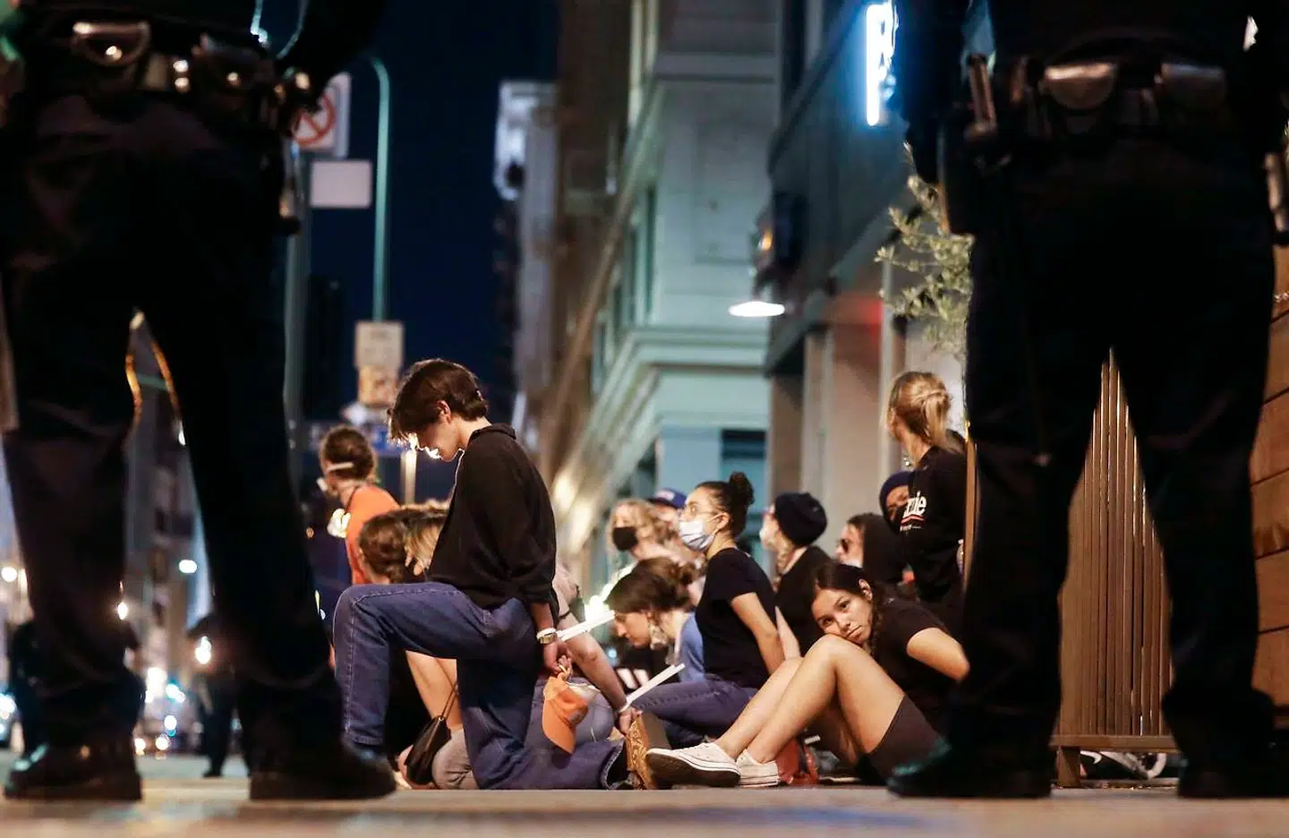 Arresterede demonstranter sidder tæt sammen under en demonstration i Los Angeles. Politiet har et stort medansvar for at forhindre smittespredning i forbindelse med protesterne, mener Alexandra Phelan fra Georgetown University.