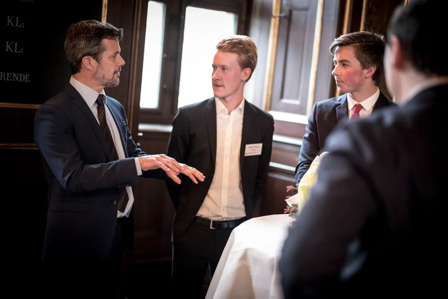 Ved nytårskuren hos Fonden for Entreprenørskab fik Anders Thuesen (midtfor) og Alexander Gram Jensen (til højre) lejlighed til at fortælle kronprins Frederik om deres samarbejde siden 8. klasse om at få en virksomhed op at køre, hvor de sikrer, at undertekster læses op for ordblinde og svagtseende gennem en mobilapp – og med stadig bredere rygdækning fra investorer, der tror på deres projekt.