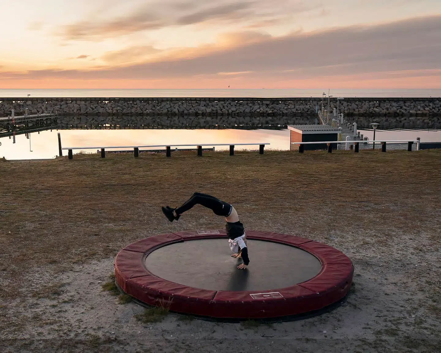 Anna Thorsen Pedersen på ti år nyder solens sidste stråler fra Læsø Marina Parks trampolin. Bag hende står enden af Østerby Havn usædvanligt tom. På dette tidspunkt plejer der at være fyldt med svenske lystbåde. Ingen ved, hvornår de må lægge til igen.