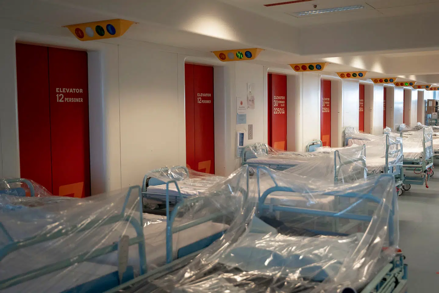 På hver etage i elevatortårnet står rene senge klar til at blive taget i brug. På 7. etage af Herlev Hospital findes Lungemedicinsk Afsnit. Her er halvdelen af afsnittet omlagt til at behandle coronasmittede patienter. Her modtager de patienter, som enten er mistænkt for at være smittede eller har Covid-19. Derfor er den ene halvdel af afdelingen afskåret fra den anden, for at mindske risikoen for smitte.