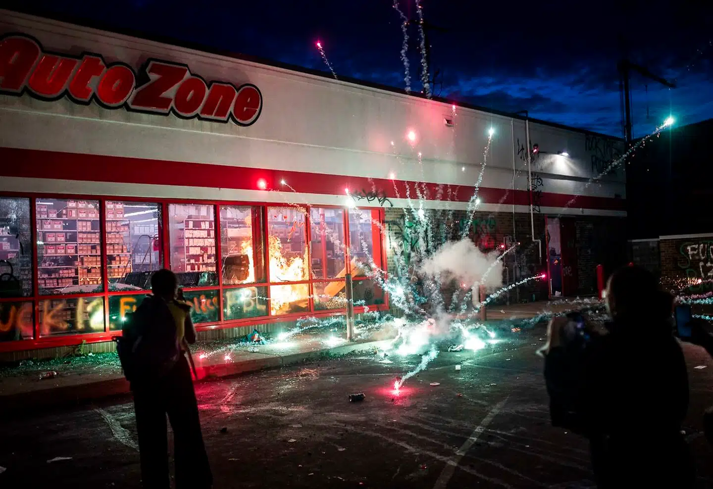 Demonstranter smider med fyrværkeri ude foran en Auto Zone-butik nær polities hovedkvarter.