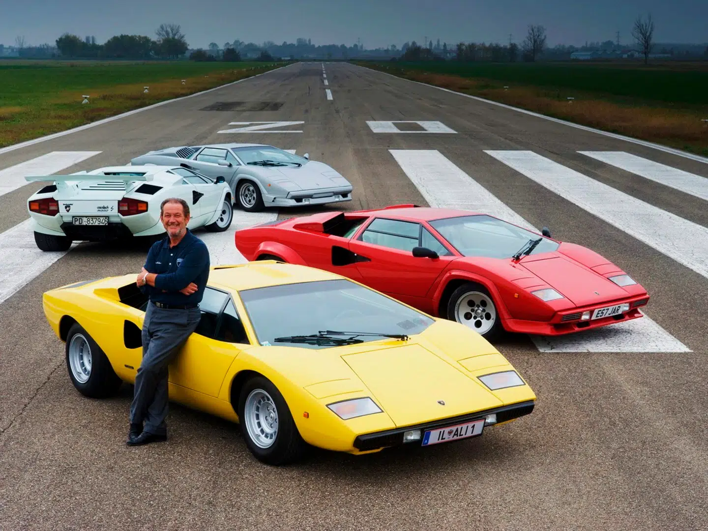 Lamborghini-testkøreren Valentino Balboni i sine velmagtsdage foran en stribe Lamborghini Countach.