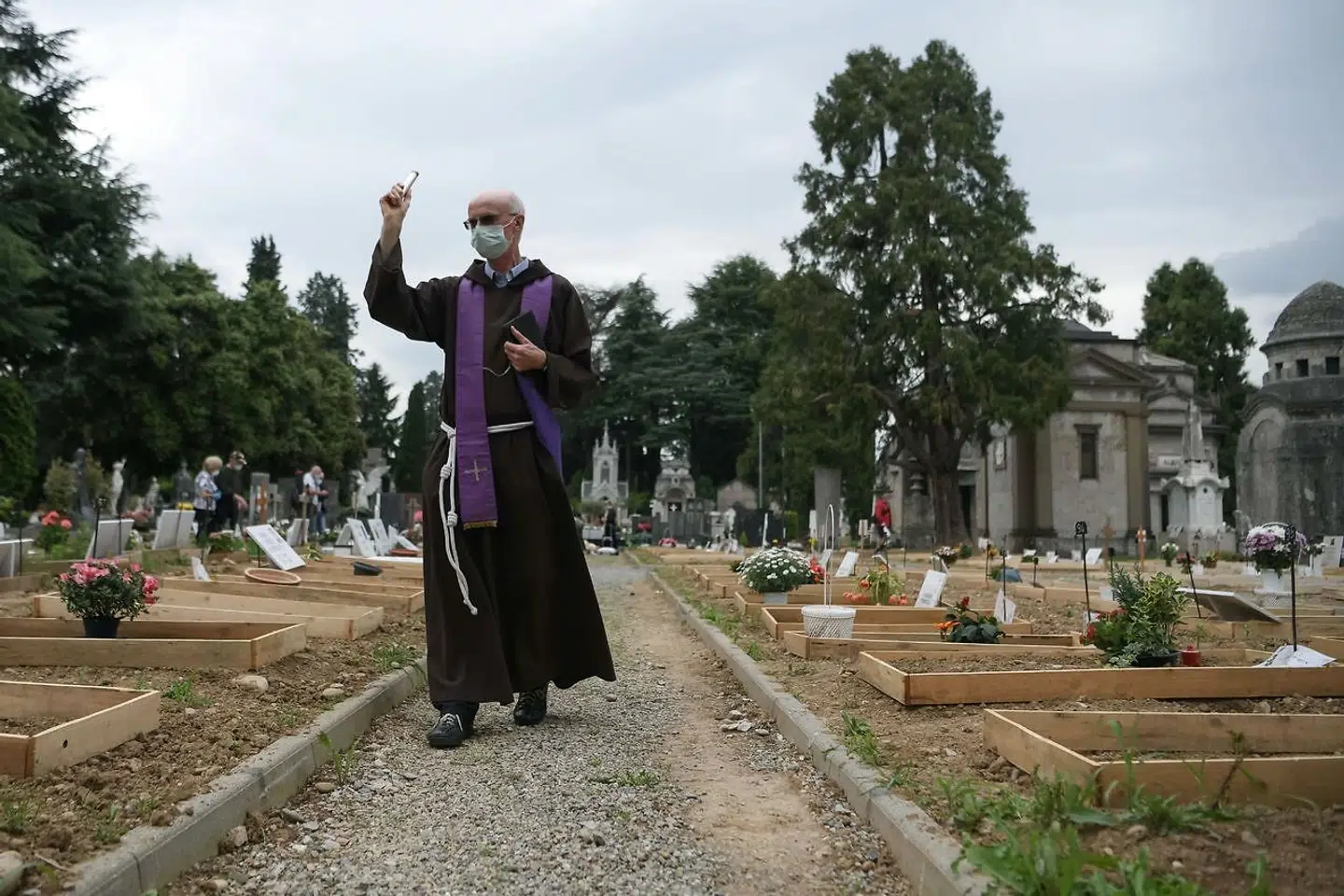 En præst velsigner de nye grave i Bergamo, mens regionen langsomt begynder en genåbning.