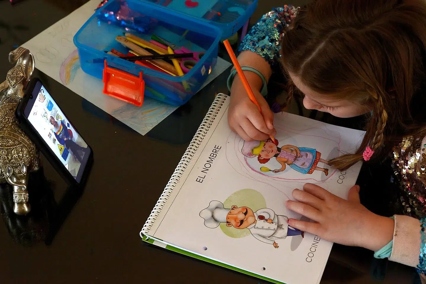 En seksårig pige modtager fjernundervisning. Spanske børn og unge bruger samtidig mobiler, tablets og PCer flittigt til at spille og chatte under karantænen.