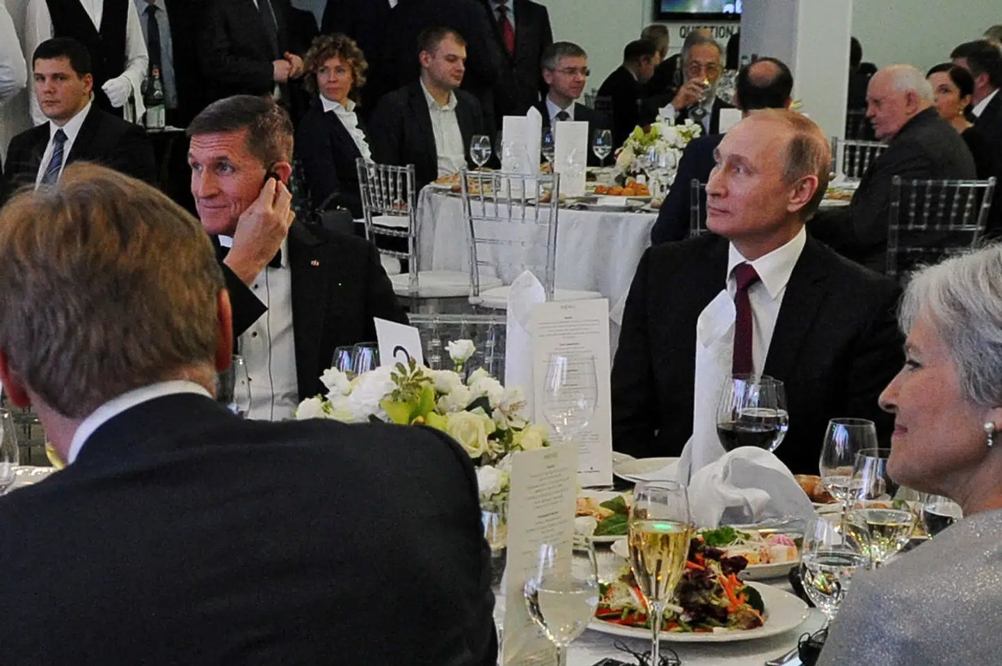Michael Flynn til højbords med Vladimir Putin i december 2015 under en markering af tiåret for den russiske TV-station Russia Today i Moskva. Under arrangementet var Flynn med til at incitere stående ovationer for Putin.