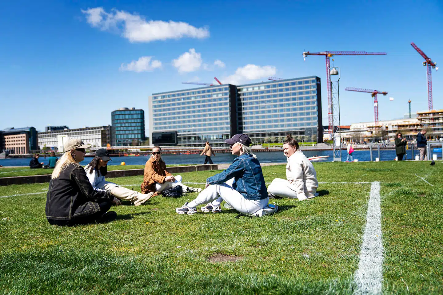 Folk nyder solen på Islands Brygge i København. De afmærkede arealer skal hjælpe borgere med at holde afstand. Hvert felt er på 40 kvm, hvori der kun må opholde sig ti personer.