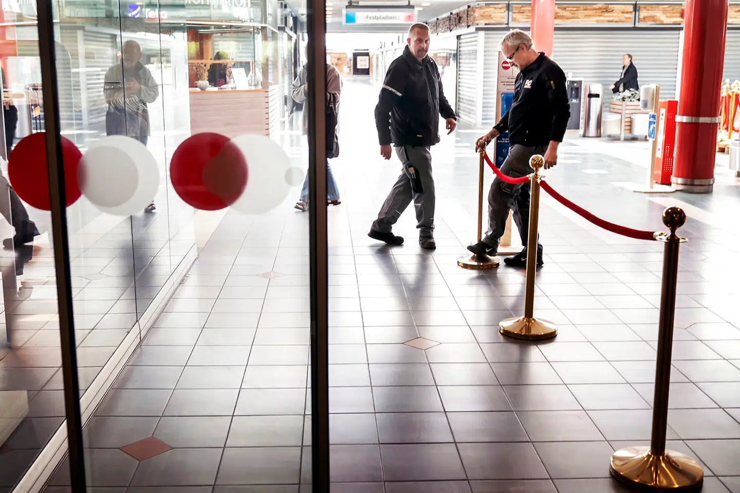 Medarbejdere opsætter bånd for at ensrette gangarealerne.
