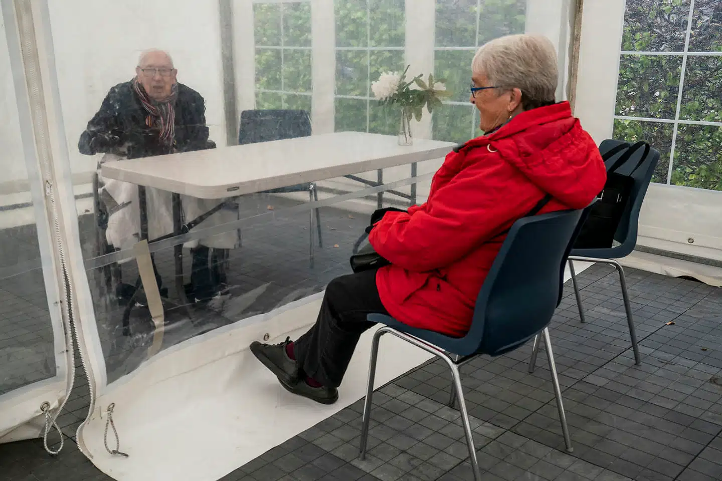 Plejehjem Nymosehave i Gentofte har knækket koden til, hvordan de kan lade deres plejehjemsbeboere få besøg af pårørende uden smitterisiko. Et af de par, der nyder godt af den nye ordning, er Aase og John. De mødes i et havetelt, der er sat op på plejehjemmets parkeringsplads, hvor de kan mødes med en gennemsigtig telt dug imellem sig.